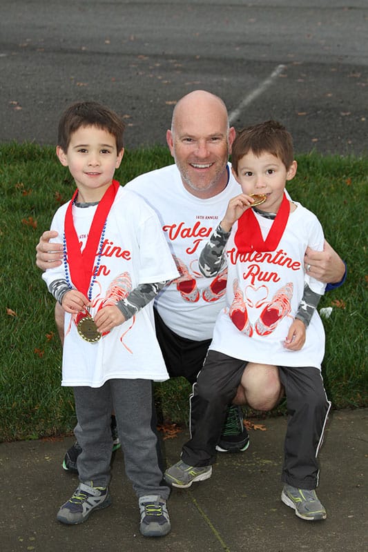two boys and a man after a marathon
